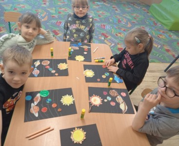 Na zdjęciu dzieci wykonują pracę plastyczną ,,Wirujące planety'.  - powiększ